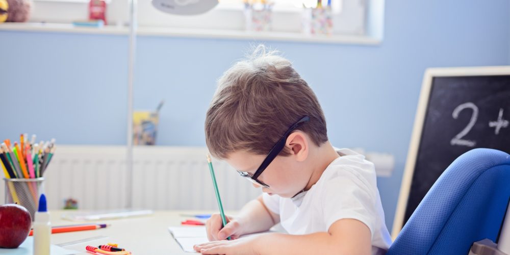 Image showing a boy writing at a desk