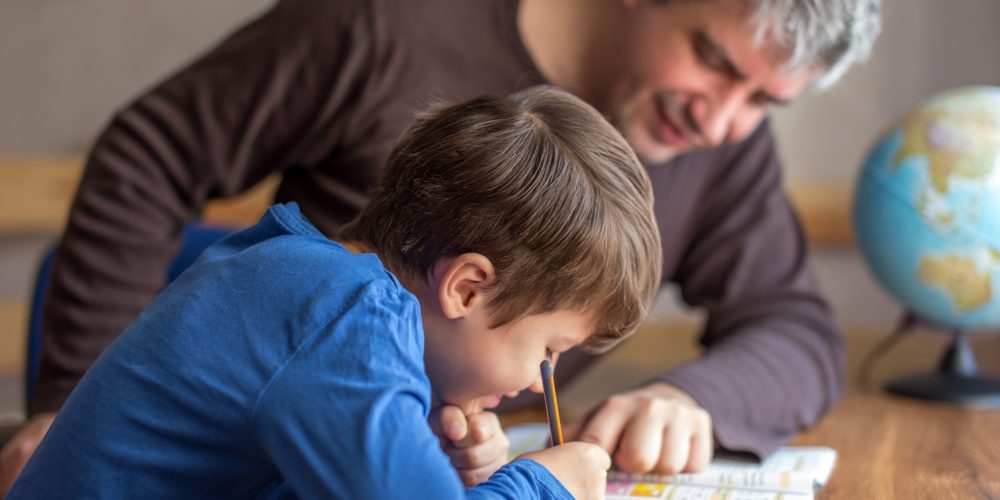 Image showing parent and child writing in an activity book