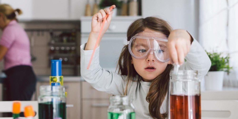 Image showing a young girl wearing science goggles playing with colourful liquids