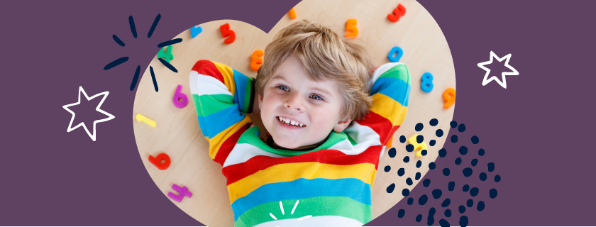 Image of a boy lying on his back and smiling