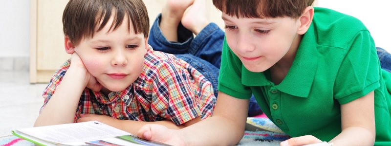 image of two boys on the ground reading